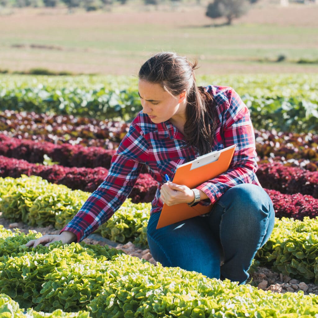 Woman in a field taking notes